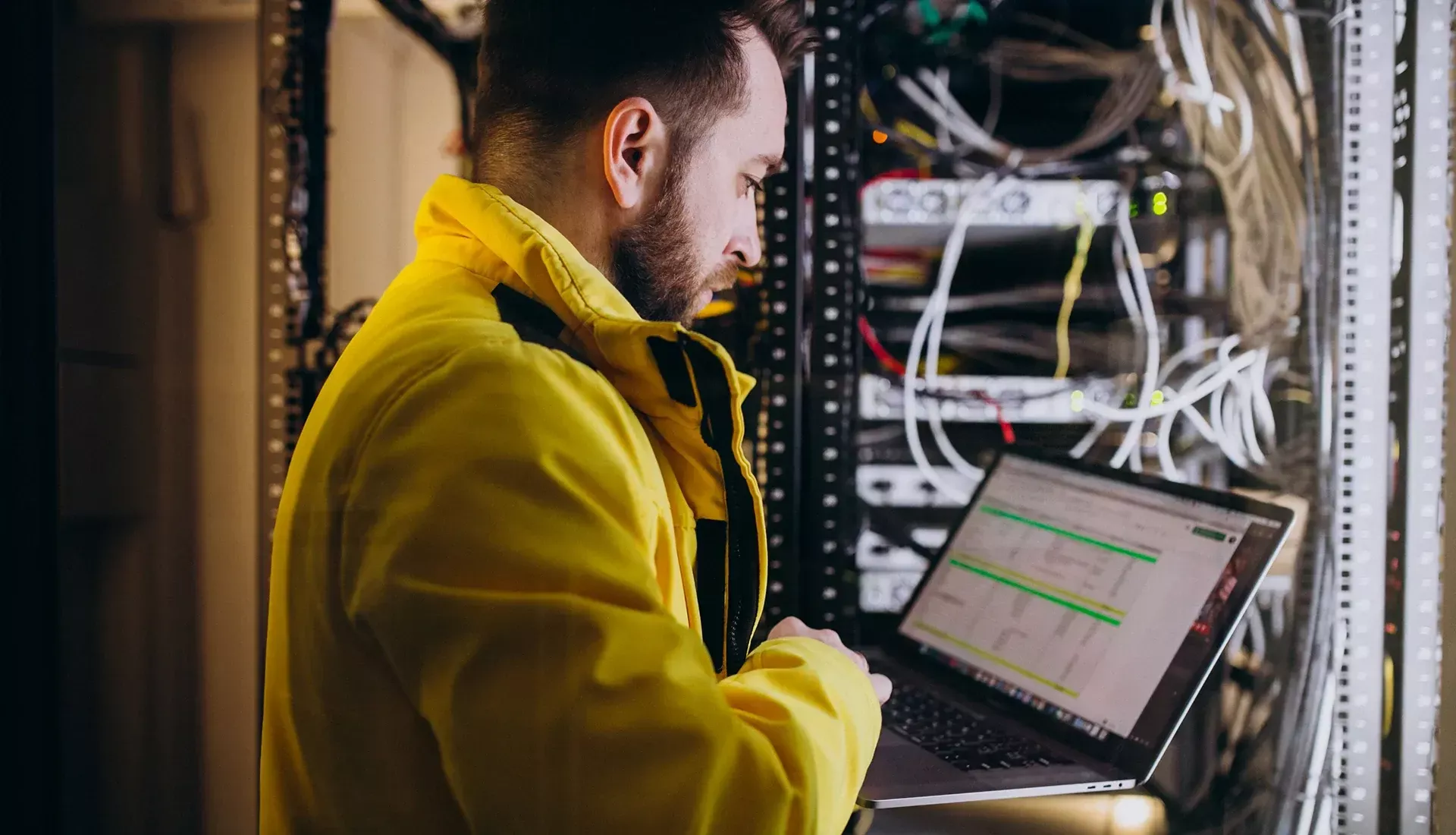 Ein Elektriker mit Laptop in einem Serverraum
